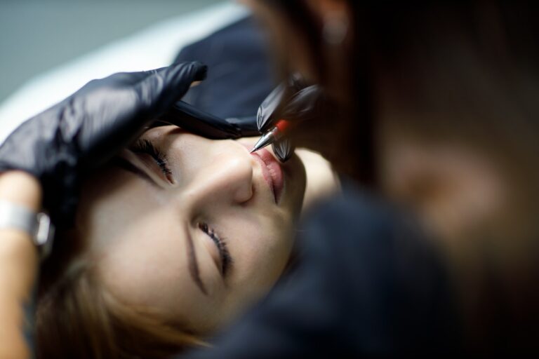 Cosmetologist applying drawing contour on lip before making lips microblading tattoo procedure.